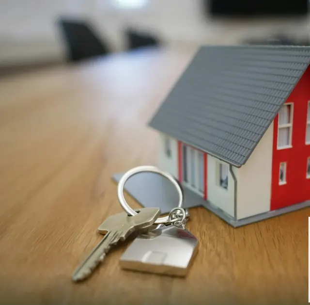 A key and a model house on a desk
